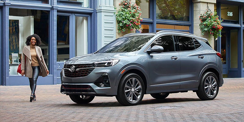 girl passing by grey Buick Encore GX