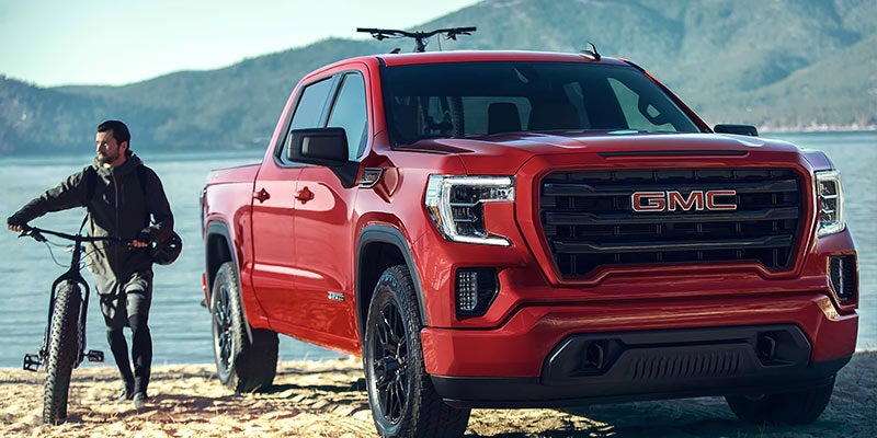 red GMC Sierra 1500 near lake